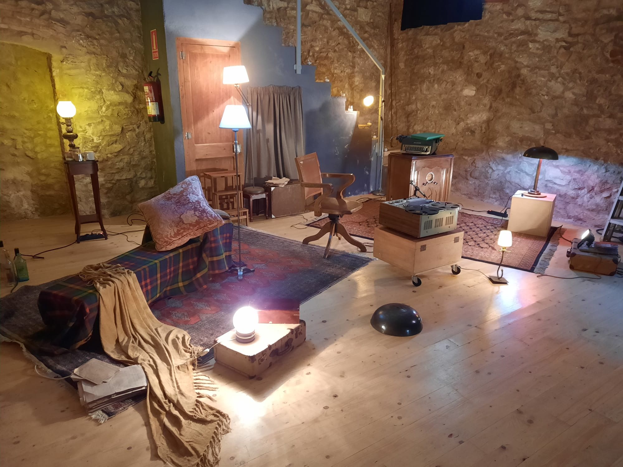 Sala de pedra amb llum càlida i un sofà com a escenari