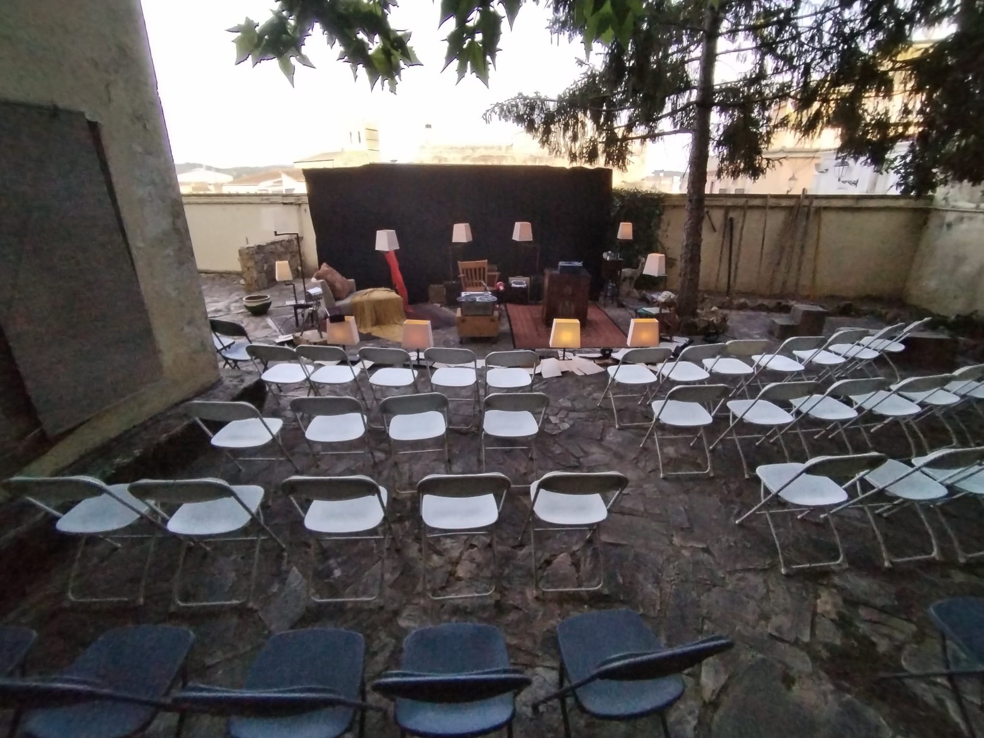 Pati amb files de cadires davant d'un escenari improvisat
