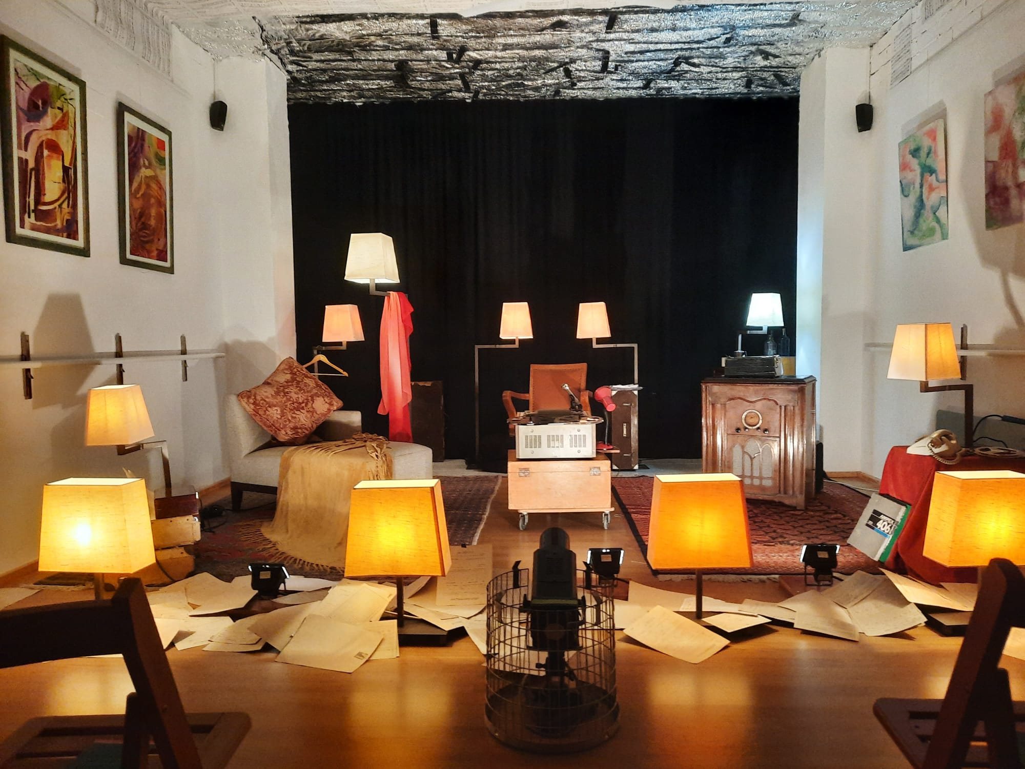 Sala amb làmpades enceses i mobles antics preparada com a escenari