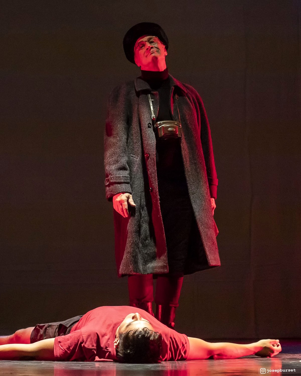 Escena de L'últim viatge de Rudolf Nureyev: el fotògraf dret i un ballarí estirat a terra, amb llum vermella